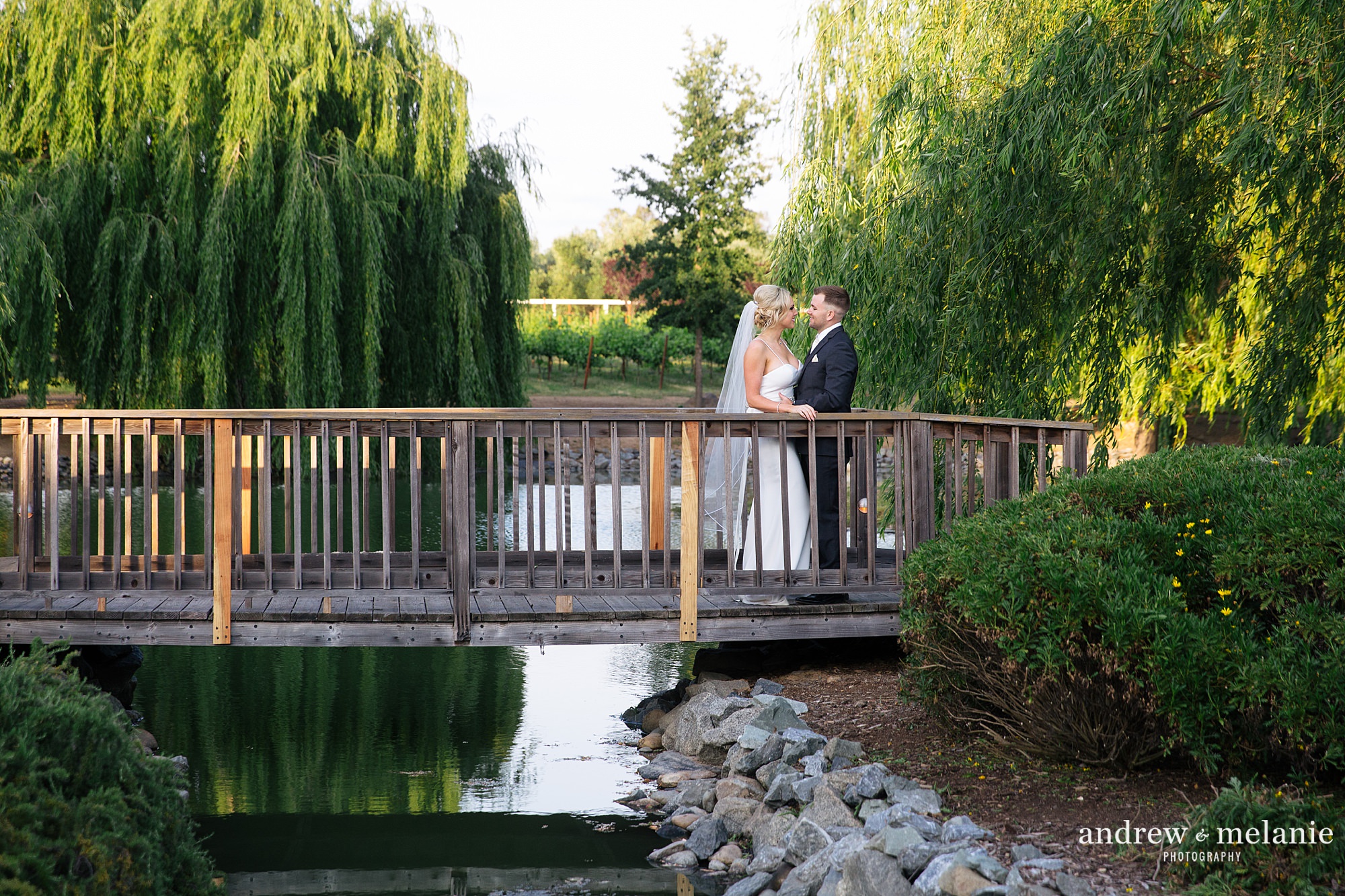 Wolfe Heights Event Center in Sacramento, CA. Spring wedding photos on bridge overlooking pond